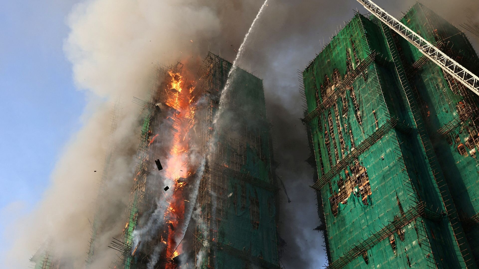 At least 13 people dead and unknown number trapped after huge fire engulfs Hong Kong high-rise